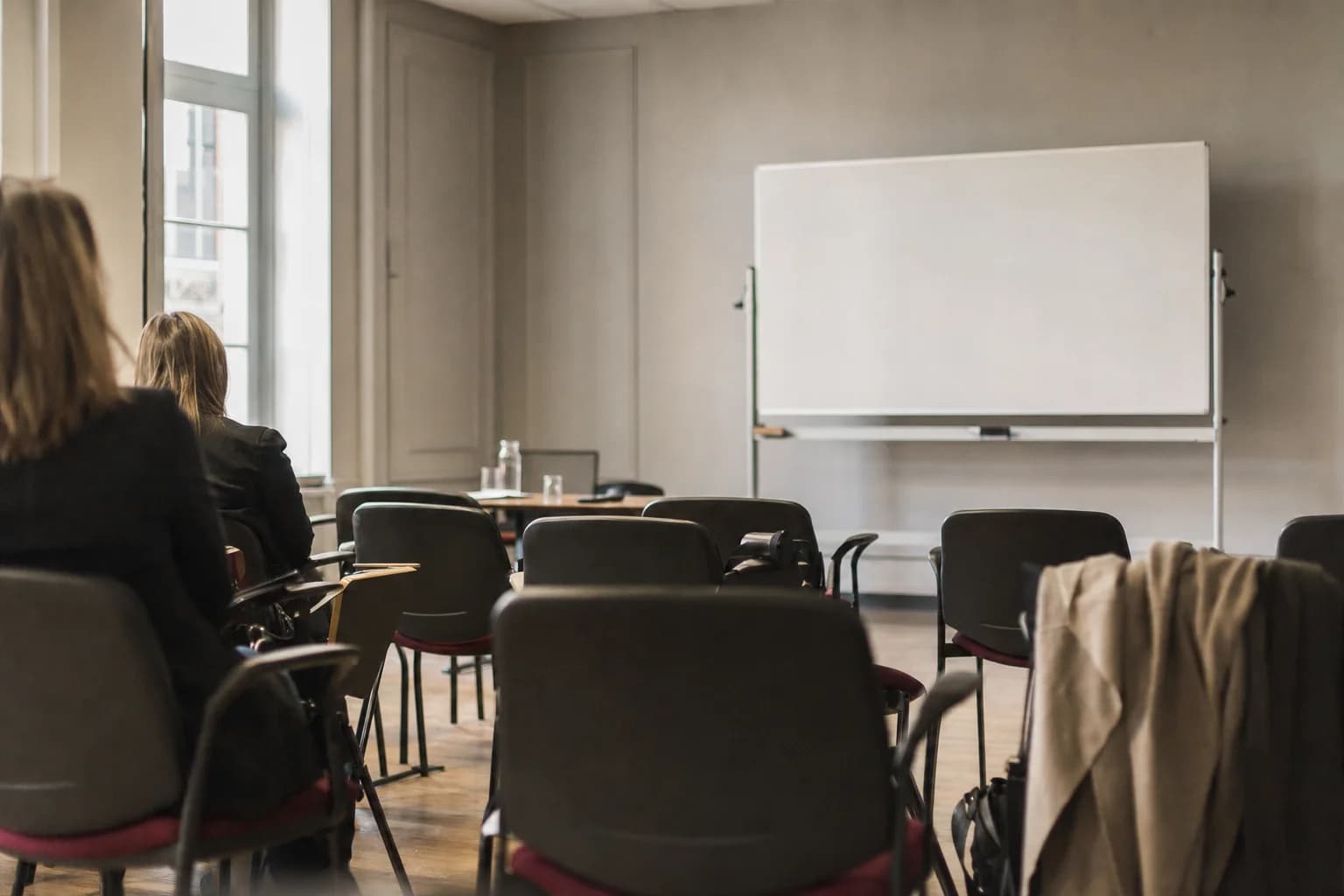 Une salle de formation, des rangées de chaises face à un tableau blanc